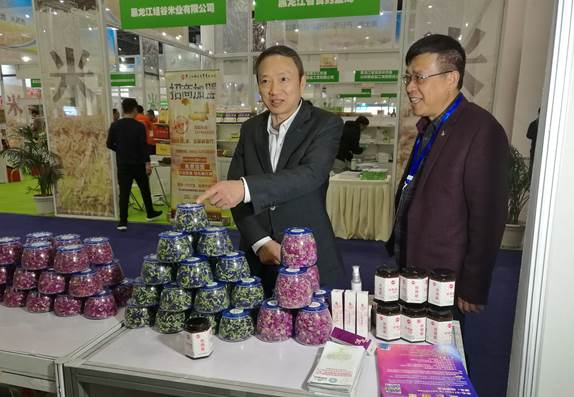 省委臺辦主任周敏謙（左）在四川雙龍農牧開發有限公司展臺與臺商林云飛（右）親切交流