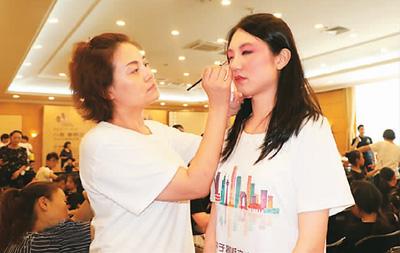 圖為京劇老師為臺灣青年化妝。趙苗青攝