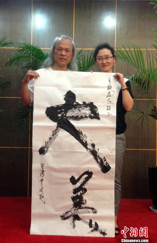 臺灣著名微雕家陳逢顯(左)書“大美”贈予云南當地人士 臺灣著名微雕家陳逢顯(左)書“大美”贈予云南當地人士