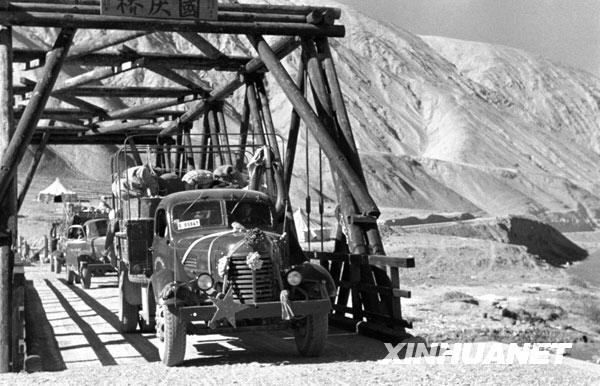 圖為從新疆開出的載重汽車正在通過拔海4000米高原上的大橋(攝于1957年)。