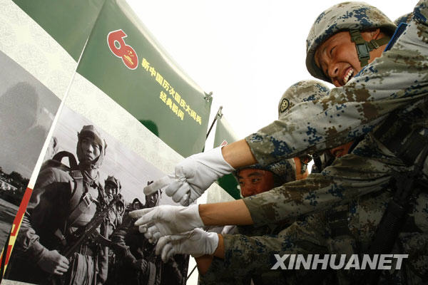9月24日,閱兵村中的空降兵方陣官兵在觀看1953年國慶閱兵式上的傘兵部隊受閱照片。