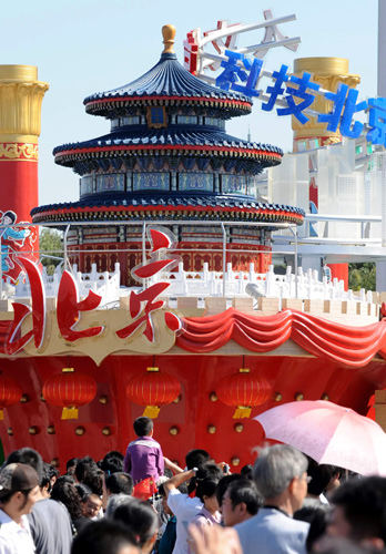 10月2日,游客在“北京之歌”彩車前參觀留影。 據了解,在10月1日國慶群眾游行中出現的彩車將從2日至7日在天安門廣場進行展示。這些彩車充分展示出新中國成立60年來取得的輝煌成就,表達了56個民族的群眾對偉大祖國的衷心祝福。 新華社記者 唐召明 攝