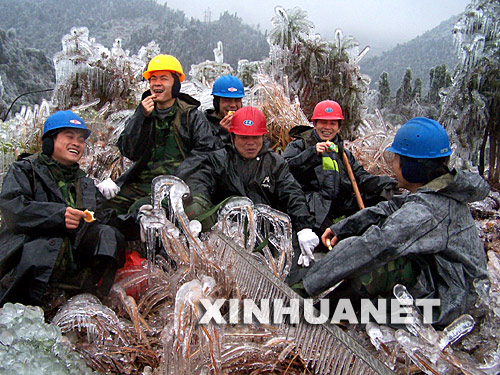 2月1日，電力工人坐在冰凍的地面上吃干糧。自1月13日以來，廣西昭平縣遭遇持續強冰凍災害襲擊，造成山上大批電力設施和電網被損。災情發生后，該縣300多名電力工人日夜搶修設施和線路，確保全縣生產和生活用電。